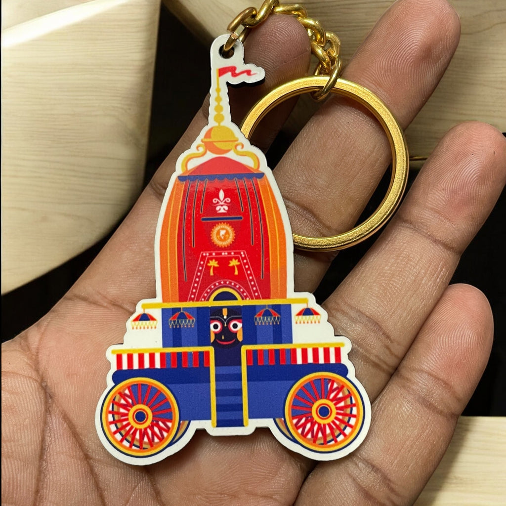 A hand holds a Jai Jagannath Key Chain from a set of 3, featuring vibrant red, blue, and yellow chariot designs with a golden keyring.